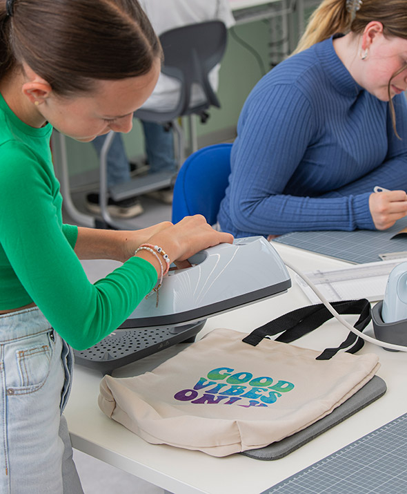 Kind presst den Plotter-Druck auf eine Stoff-Tasche