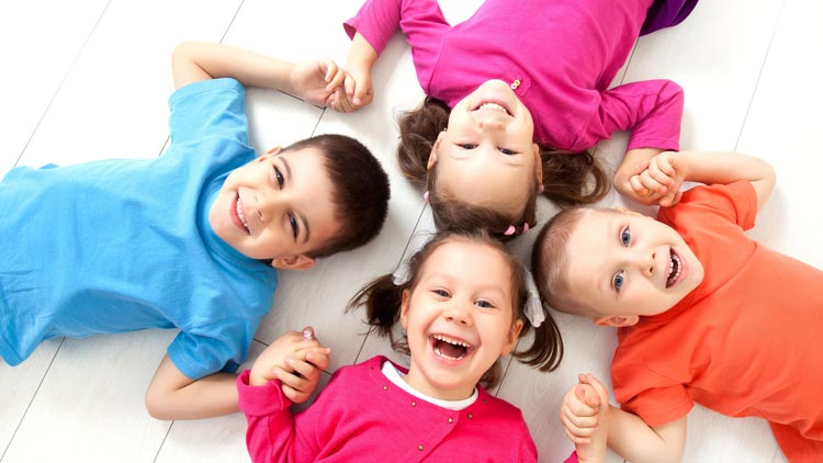 Kinder stecken ihre Koepfe zusammen